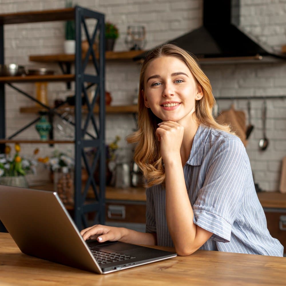 A smiling professional working on a laptop, ready to support your hiring and growth